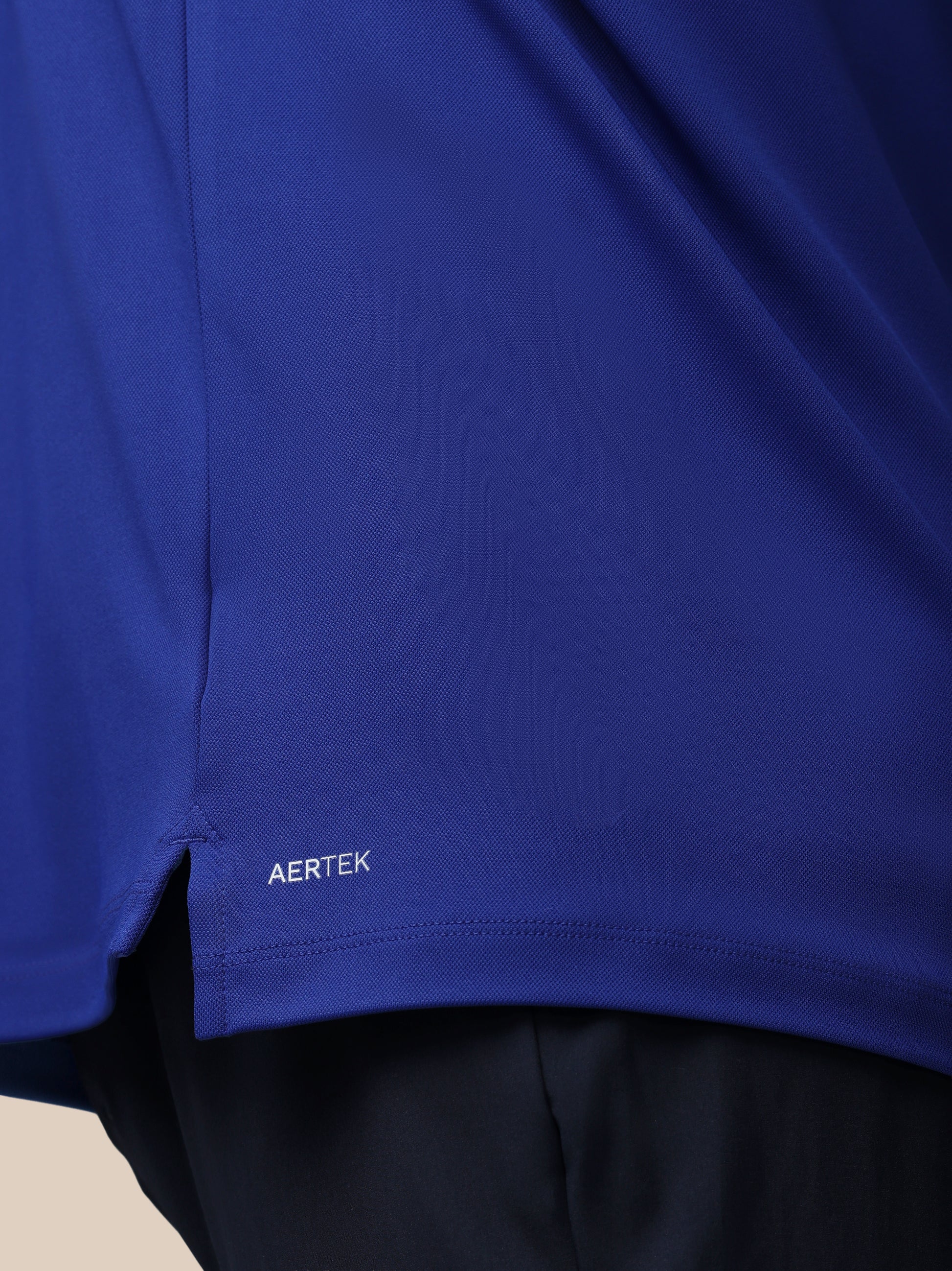 Close-up of a blue garment with 'AERTEK' branding on a neutral background