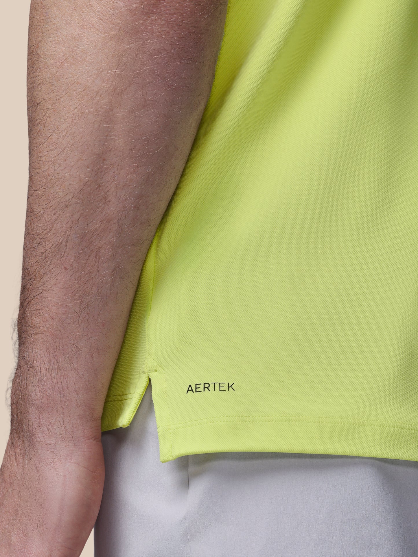 Close-up of a person wearing a bright green shirt with 'AERTEK' branding.