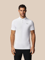 Man wearing a white polo shirt with a Castore logo on a beige background