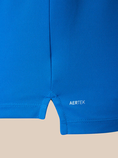 Close-up of a bright blue athletic garment showing the hem and a small white AERTEK logo on a light beige background.