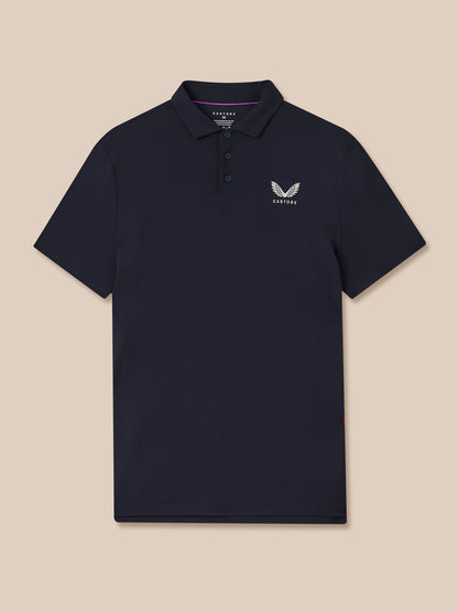 Front view of a navy Castore golf polo with left chest logo on dark fabric against beige background