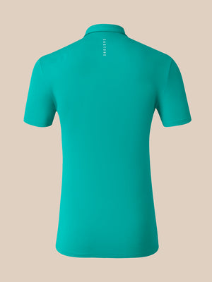 A short-sleeve polo shirt in a vibrant teal green, shown from the back against a solid beige background. The brand name 'CASTORE' is printed vertically in white near the collar.