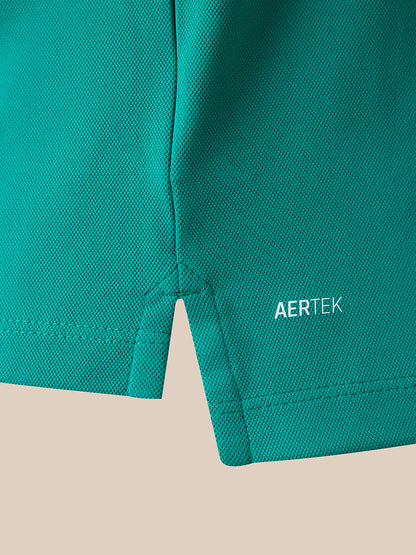 Close-up of a teal-green athletic fabric panel with a small white AERTEK logo near the lower right edge, shown against a light beige background.