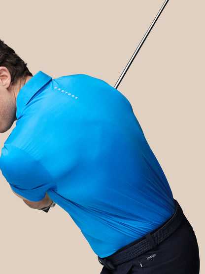 Person wearing a blue shirt and black pants, holding a golf club on a beige background