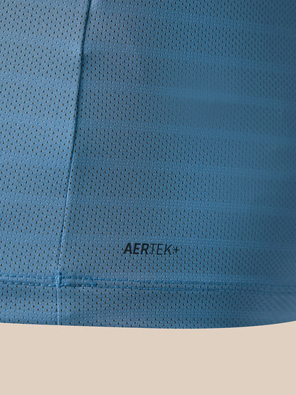 Close-up of a blue perforated athletic fabric with the AERTEK+ logo printed in black near the center, set against a light beige background.