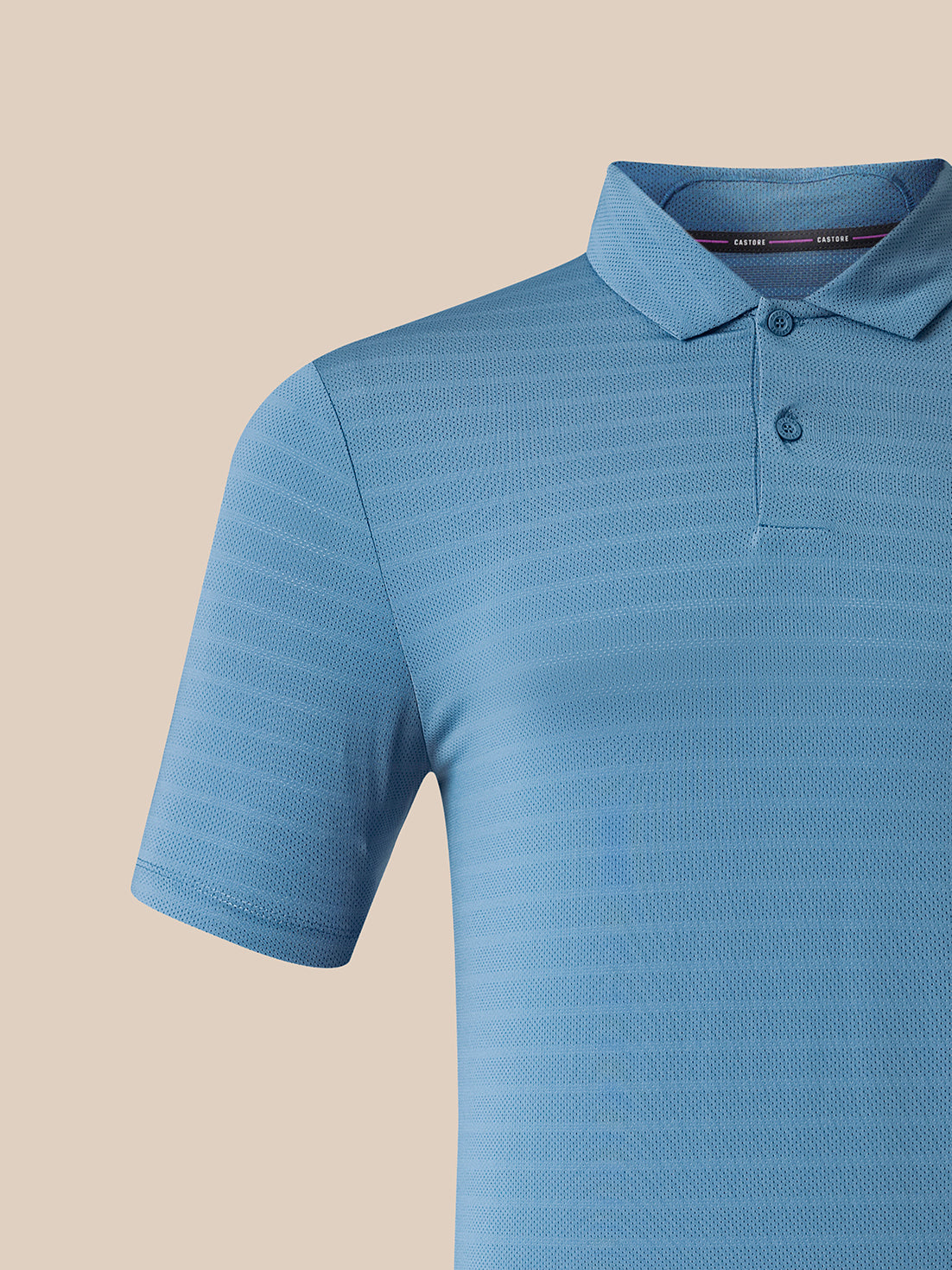 A close-up of a light blue short-sleeve polo shirt with a textured, fine-stripe pattern, set against a solid beige background.