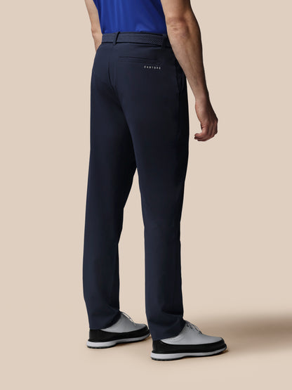 Person wearing navy pants with a visible brand logo on a beige background