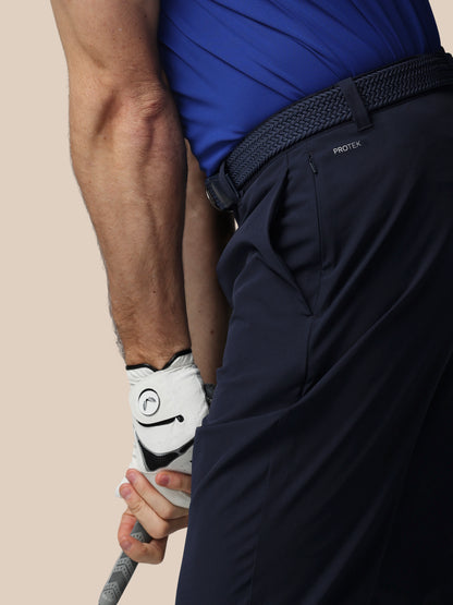 Person holding a golf club with white Castore gloves on a beige background.