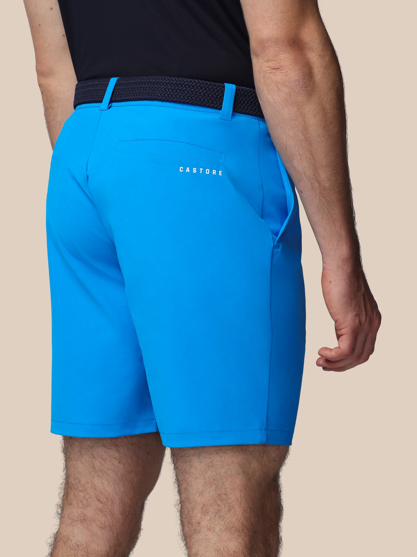 Blue athletic shorts with a visible brand logo on a beige background