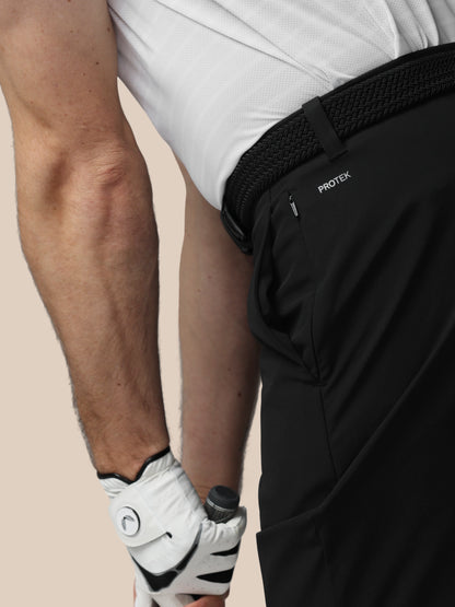 Person wearing black PROTEK pants with a beige background