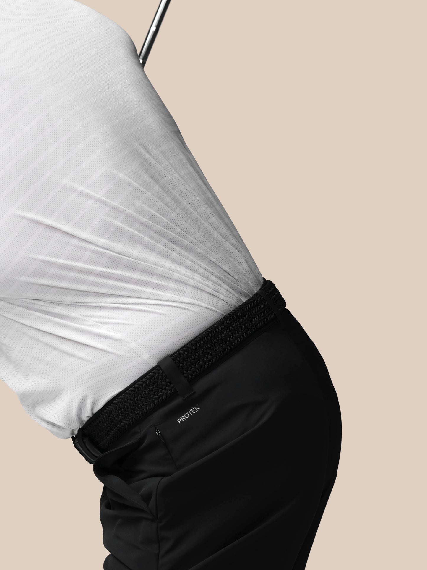 Person wearing a white shirt and black pants on a beige background