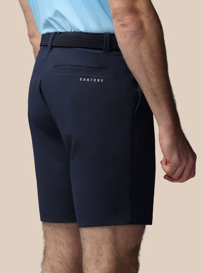 Navy shorts with a visible brand logo on a beige background