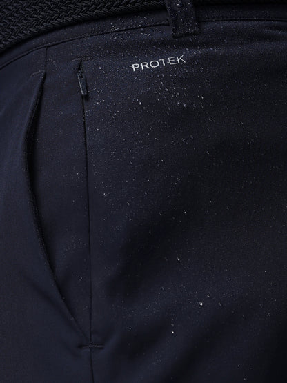 Close-up of navy pants with 'PROTEK' branding on a dark background