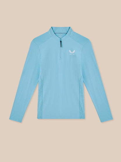 Light blue long-sleeve shirt with a brand logo on a beige background