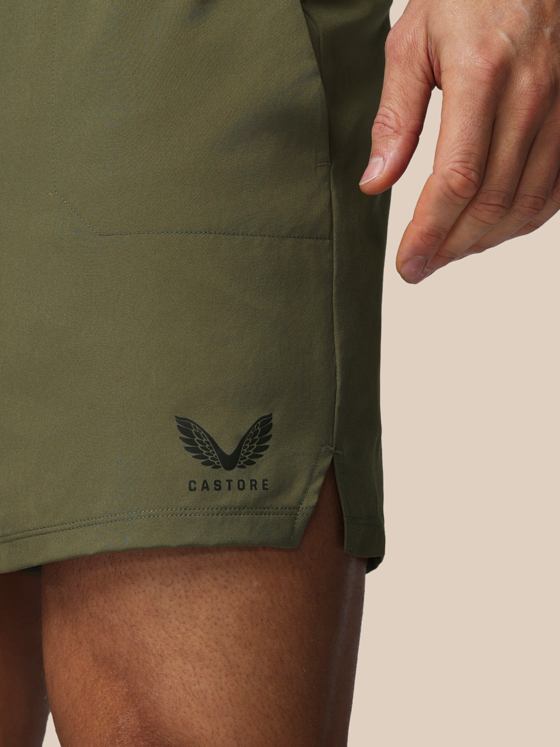 Green shorts with a brand logo on a beige background
