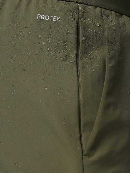 Close-up of a green jacket with 'PROTEK' branding on a textured surface.