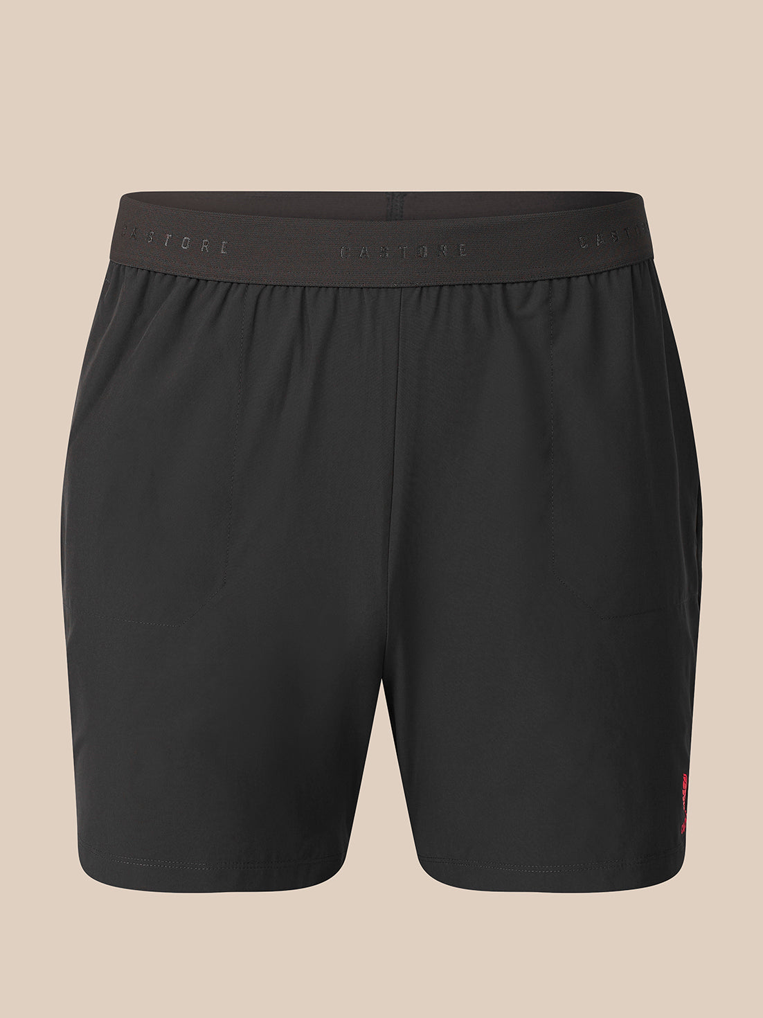 Black athletic shorts with an elastic waistband, shown against a solid beige background.