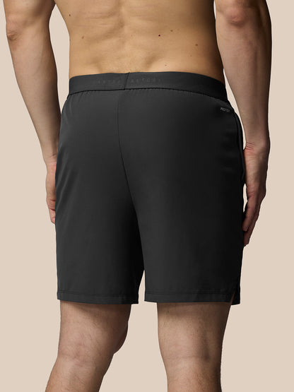Person wearing black shorts on a beige background
