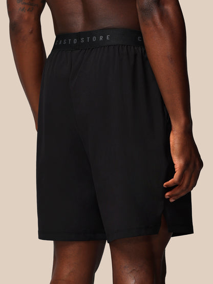 Black shorts with a brand logo on a beige background