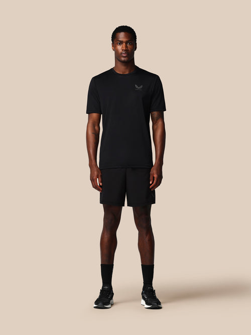 Man wearing a black t-shirt and shorts set on a beige background