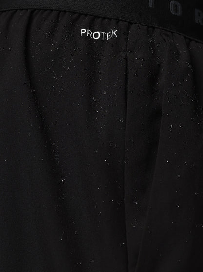 Close-up of a black jacket with 'PROTEK' branding on a dark background
