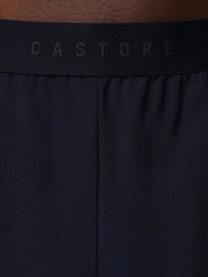 Close-up of a black waistband with 'CASTORE' branding on a brown background