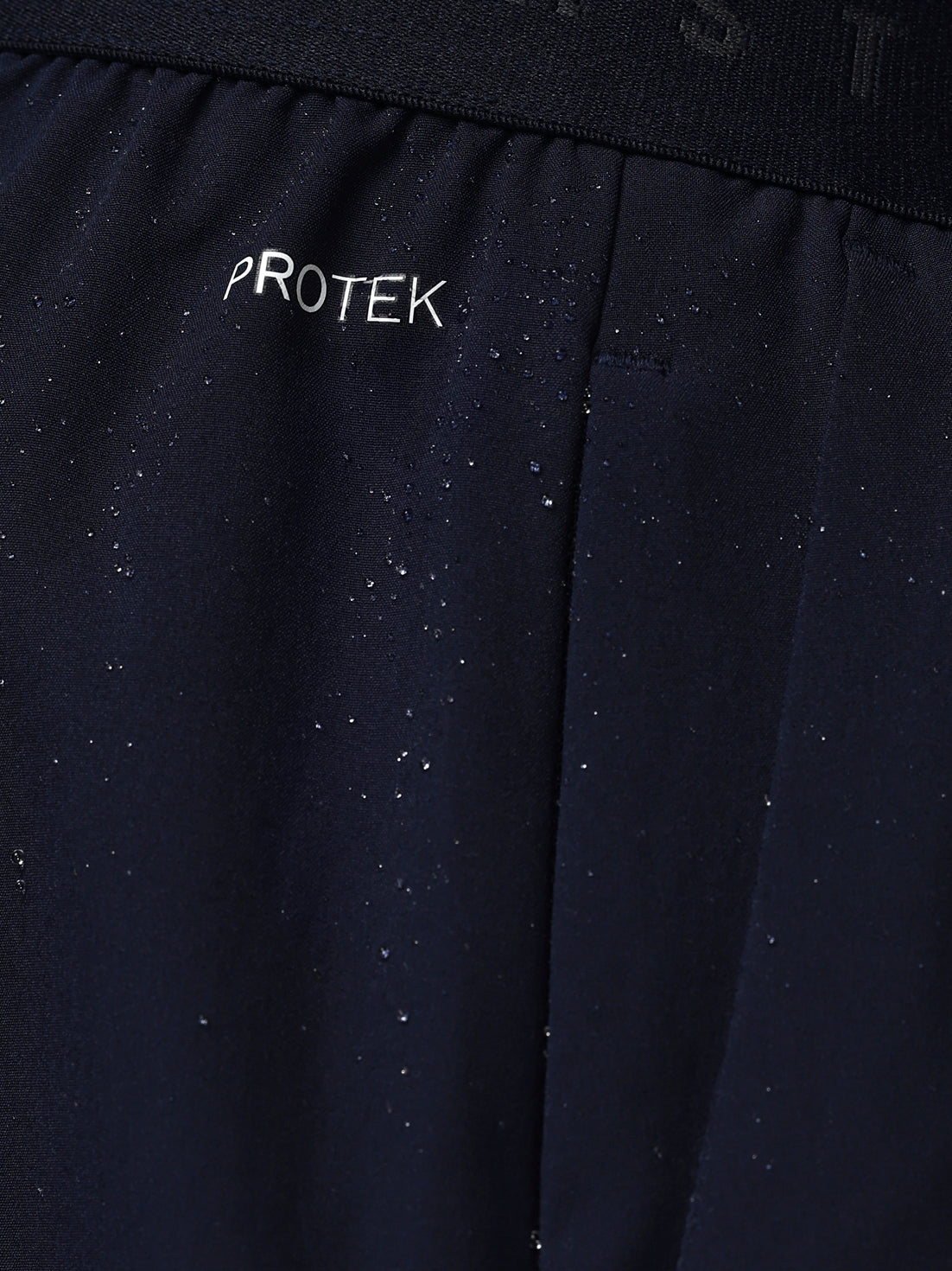 Navy blue fabric with 'PROTEK' branding on a black background