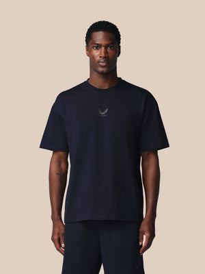 Man wearing a black t-shirt with a logo on a beige background