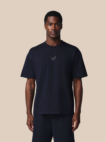 Man wearing a black t-shirt with a logo on a beige background