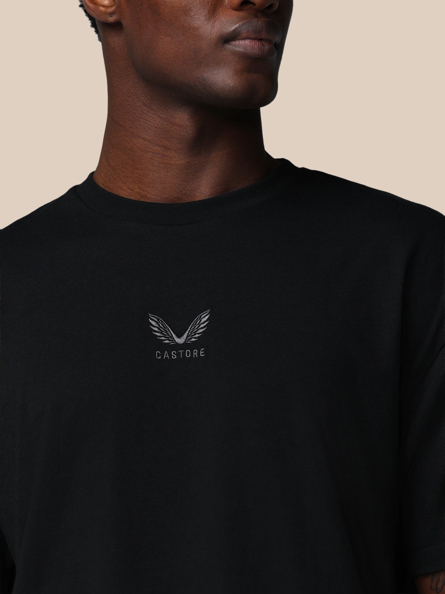 Black t-shirt with a logo and text on a beige background