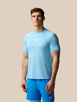 Man wearing a light blue athletic shirt and shorts on a beige background
