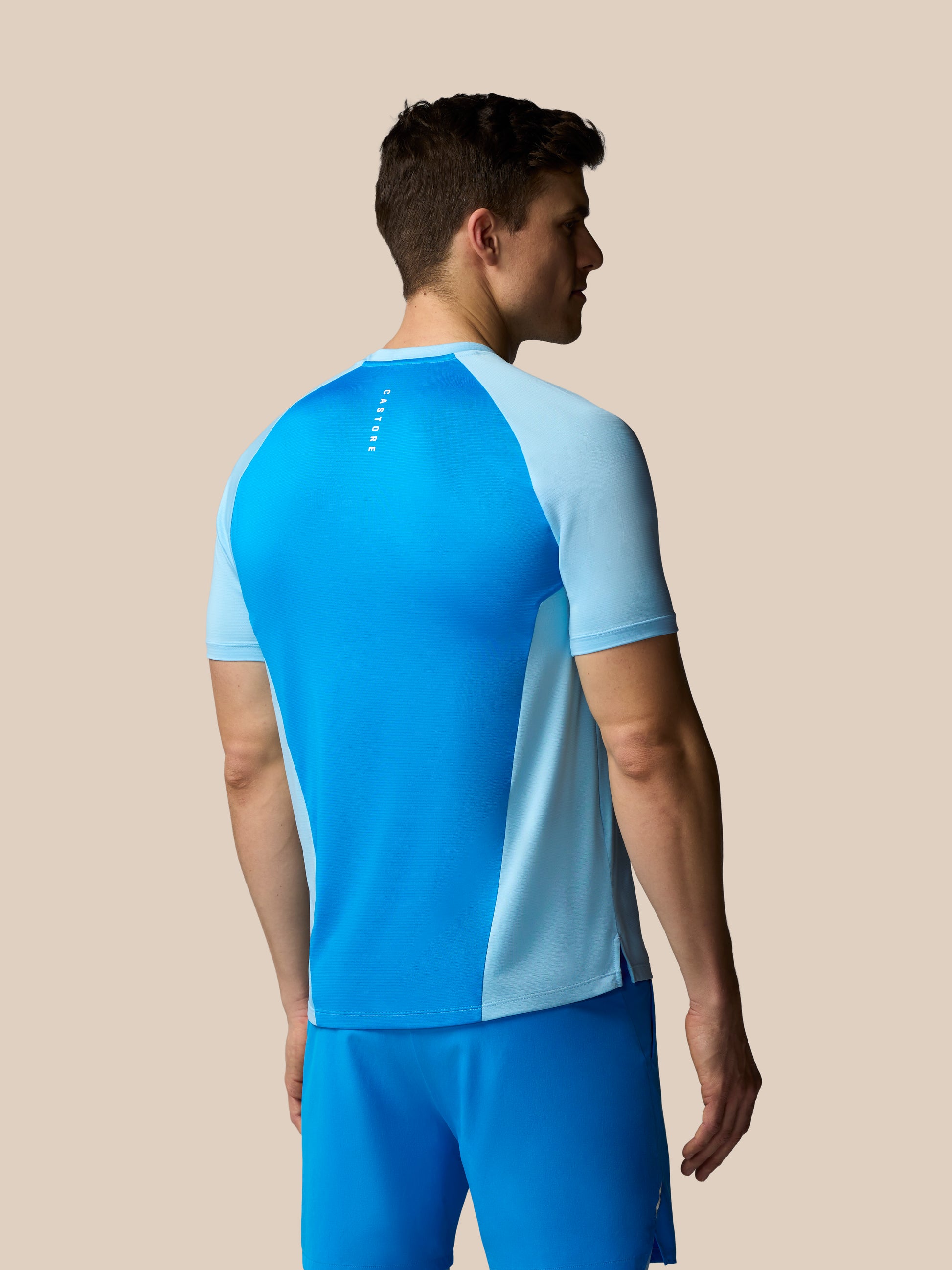 Man wearing a blue athletic outfit on a beige background