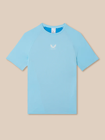 Light blue t-shirt with a small logo on a beige background