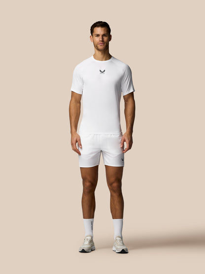 Man wearing a white t-shirt and shorts set on a beige background