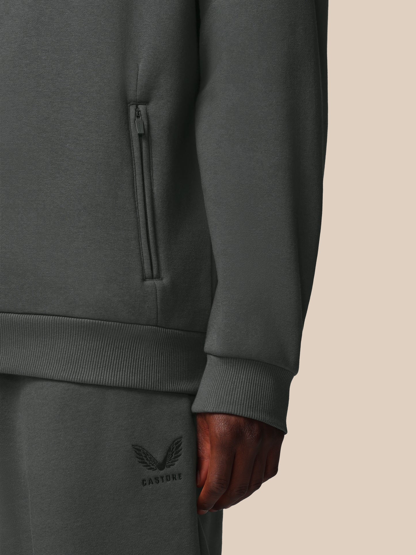Dark gray sweatshirt with a brand logo on a beige background