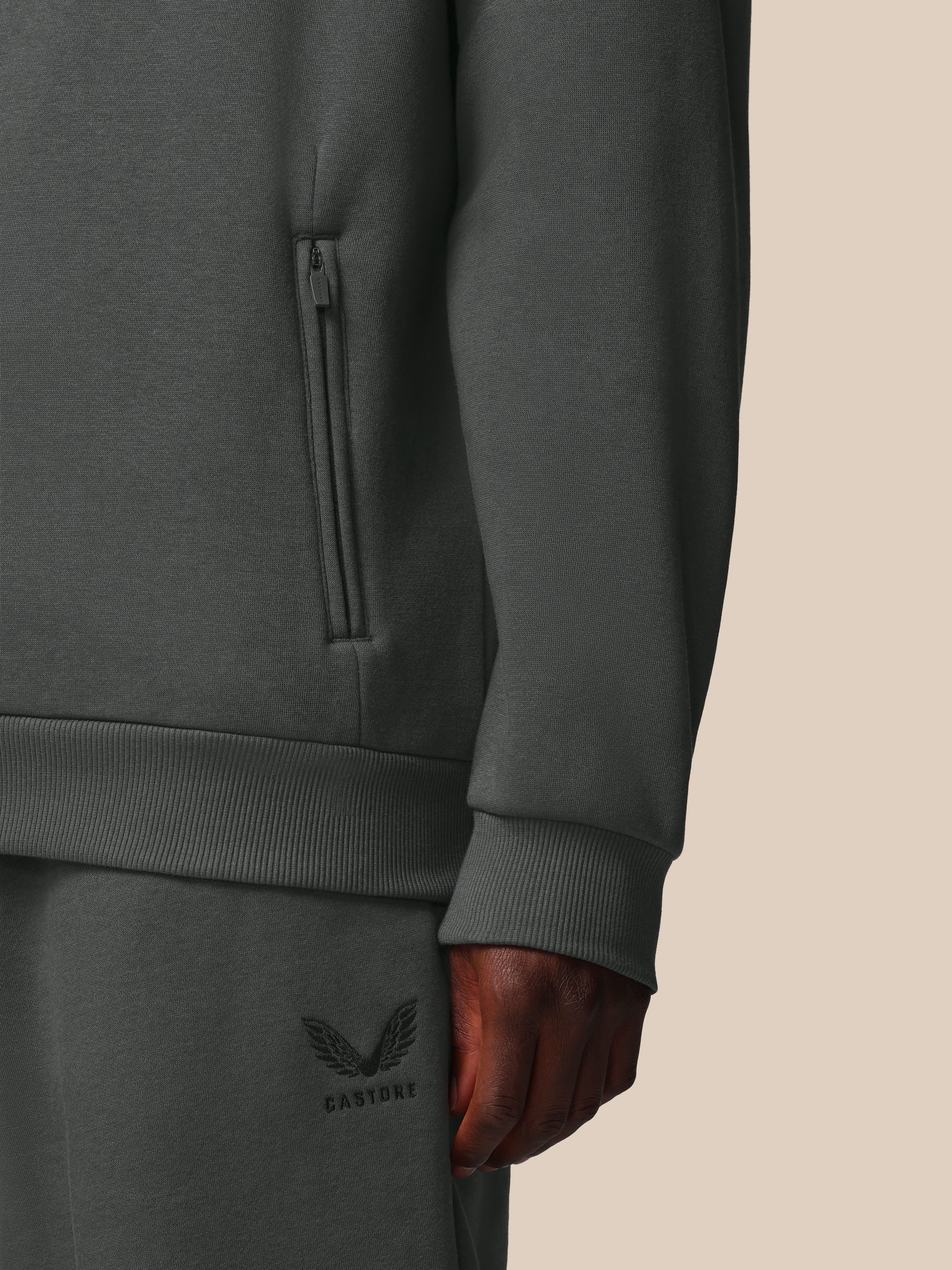 Dark gray sweatshirt with a brand logo on a beige background