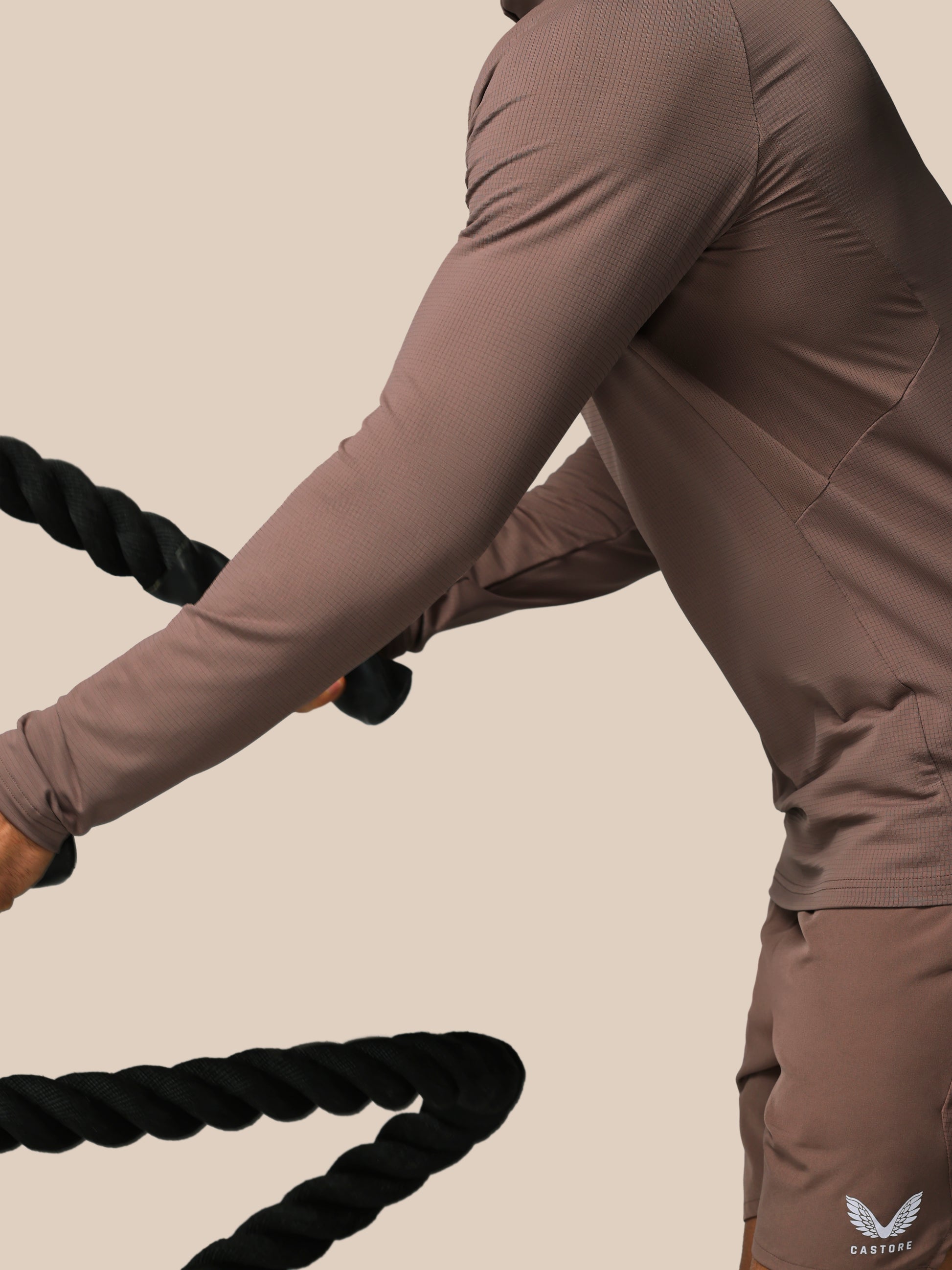 Person using battle ropes in a gym setting
