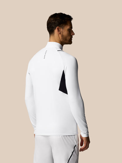 Man wearing a white long-sleeve athletic outfit with a black triangle design on a beige background