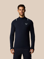Man wearing a navy long-sleeve athletic shirt with a brand logo on a beige background