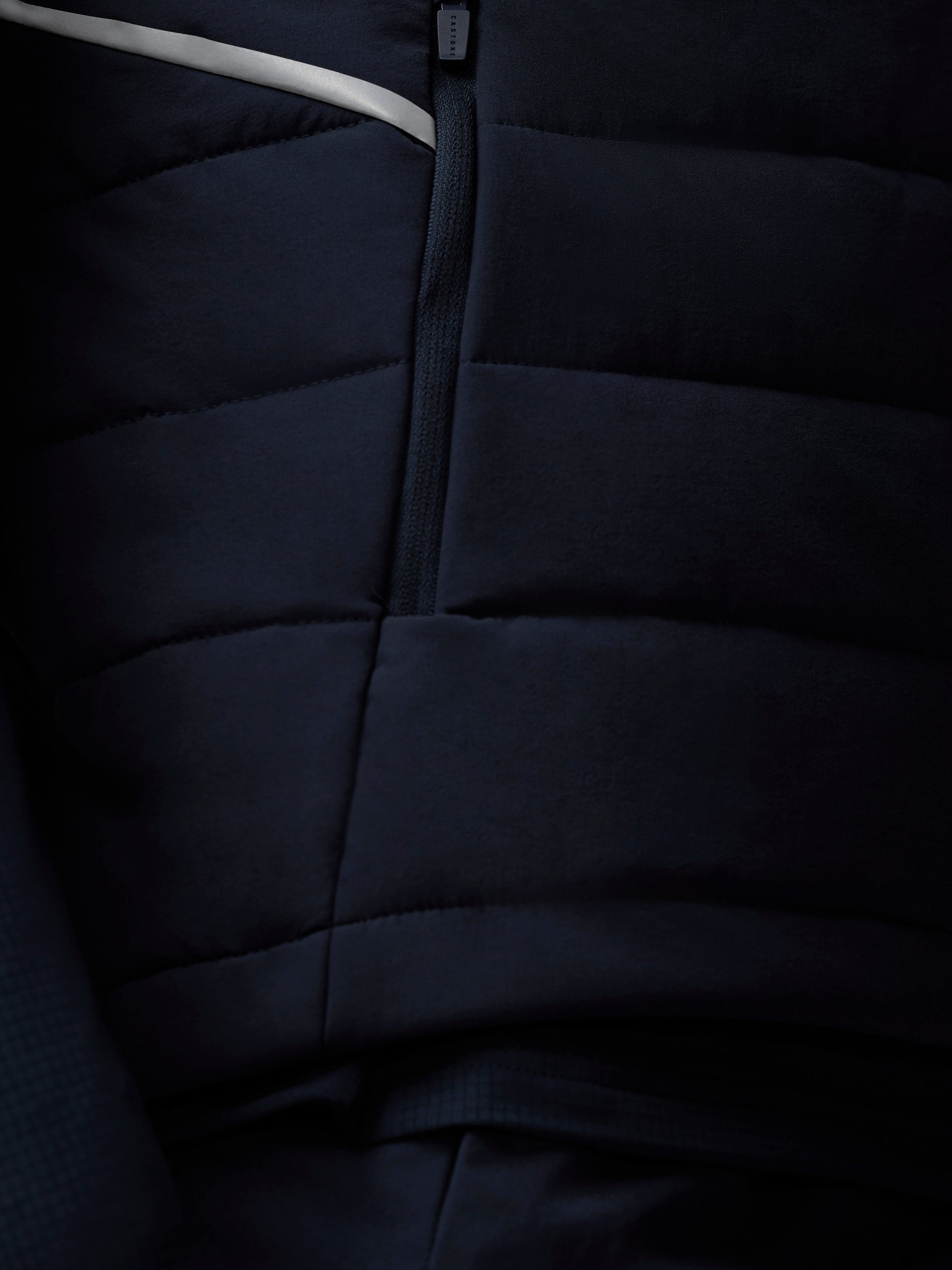 Close-up of a dark blue quilted jacket with a zipper.