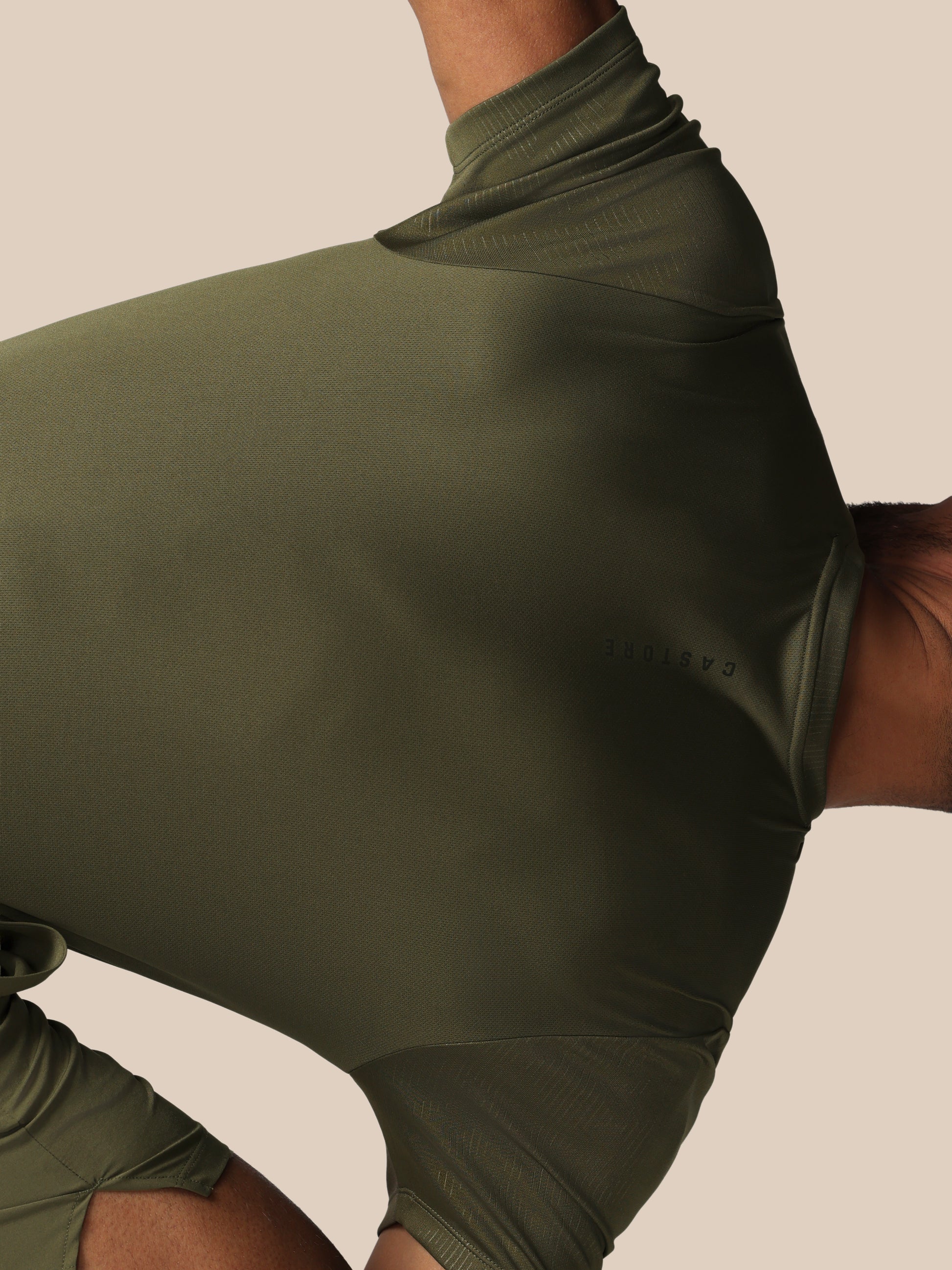 Green athletic outfit with a high neckline on a neutral background