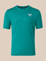 A teal green short-sleeve athletic t-shirt with a small white winged logo and the brand name 'CASTORE' printed on the left chest, displayed against a solid beige background.