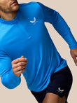 Male model wearing blue Castore Adapt All-Over Print Quarter Zip Long Sleeve Top in action with chest logo