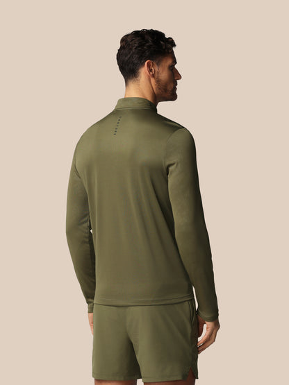 Man wearing an olive green tracksuit against a beige background