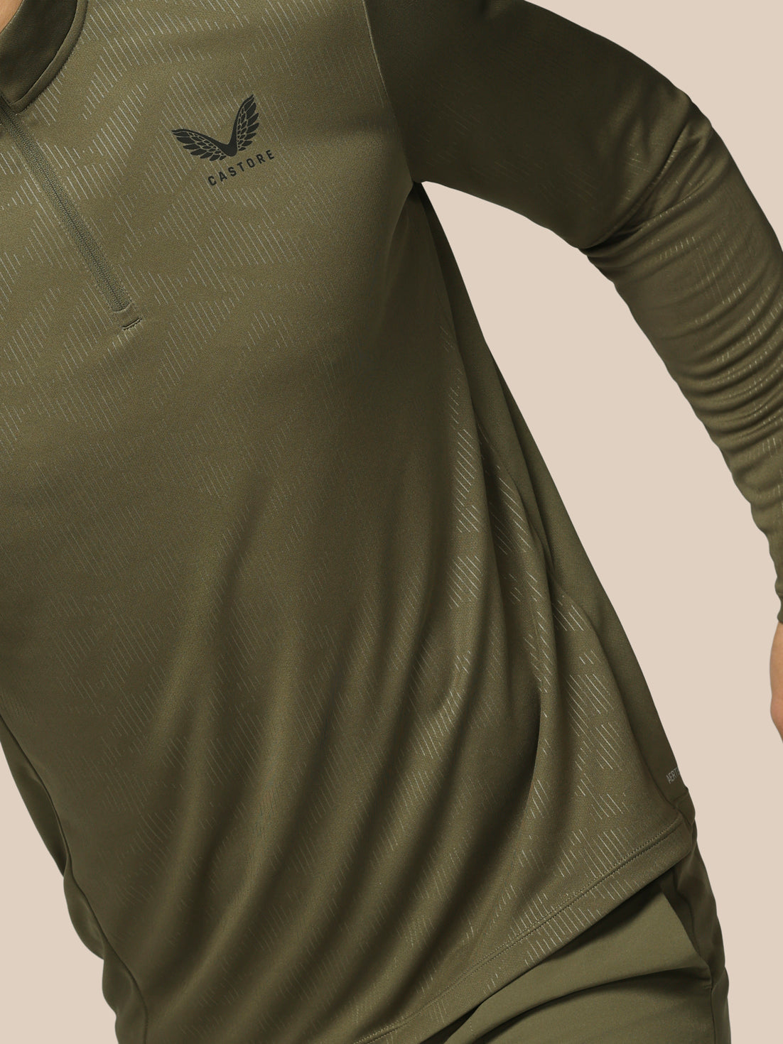 Green athletic shirt with Adidas logo on a beige background