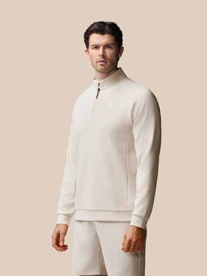 Man wearing a white outfit against a beige background
