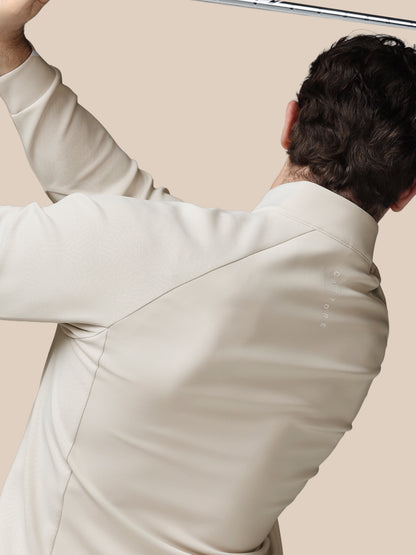 Person wearing a light-colored suit against a beige background