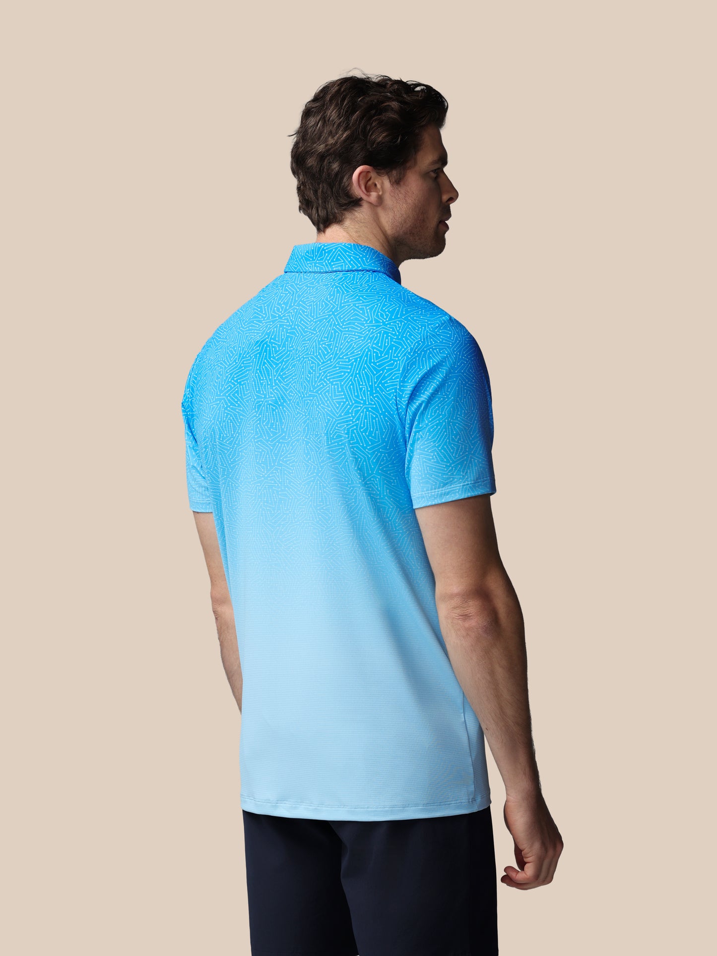 Man wearing a blue polo shirt on a beige background