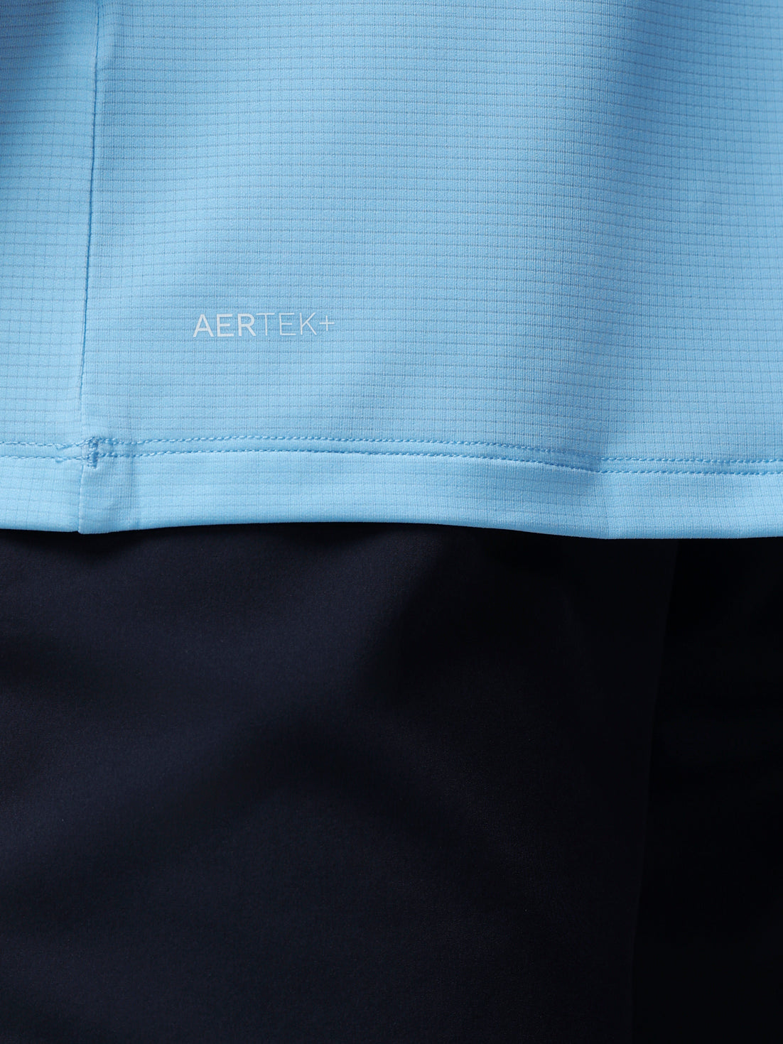 Close-up of a blue fabric with 'AERTEK' branding on a black background