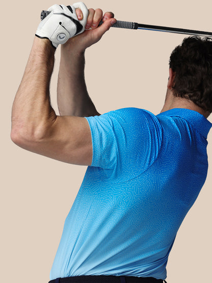 Person in a blue shirt holding a golf club against a beige background